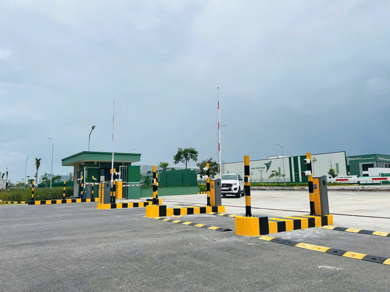 Hệ thống barie tự động và trụ kiểm soát ra vào tại cổng khu công nghiệp hiện đại